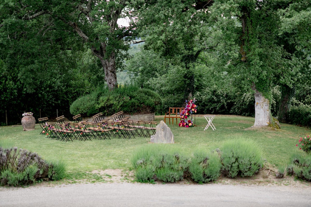 Side view of a wedding ceremony setup at Castello di Meleto, showing arranged chairs outdoors with open views across the Chianti countryside in Tuscany.