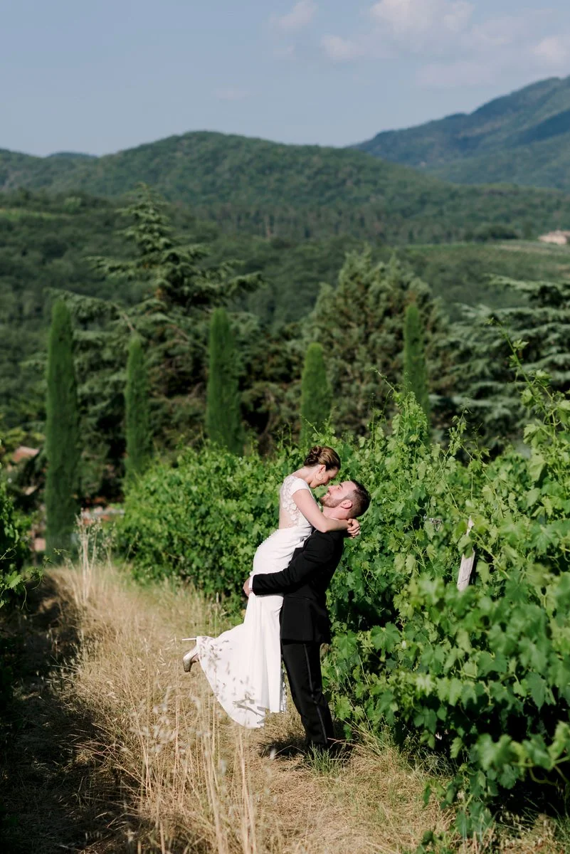 Wedding couple kissing among the vineyards at Castello di Spaltenna in the Chianti countryside.