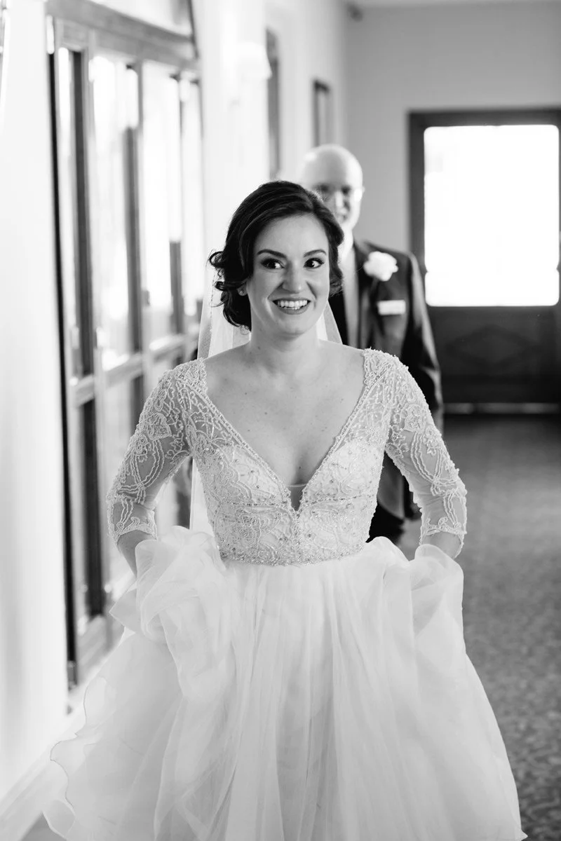 Bride smiling while walking through the historic hallway of Villa Hotel Tolomei before the ceremony. 