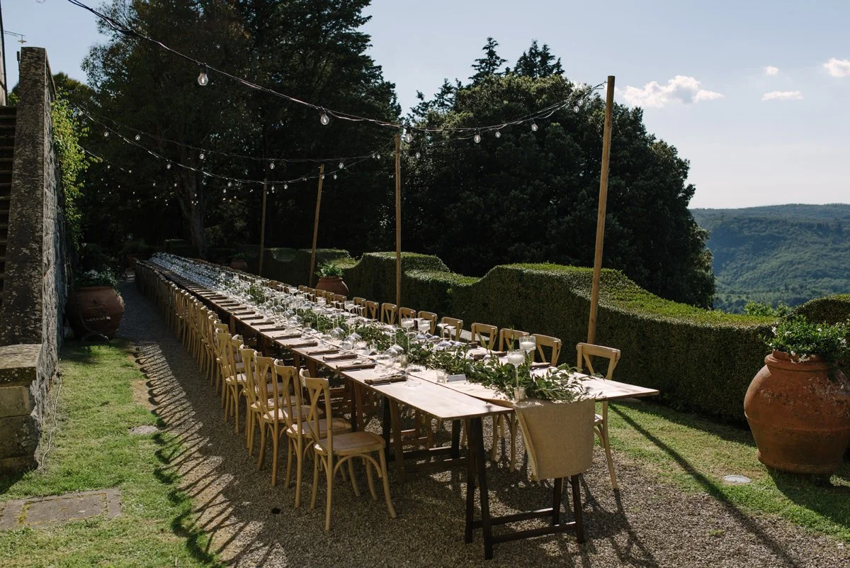 Long wedding dinner table prepared in front of the historic borgo buildings at Borgo Pietrafitta.