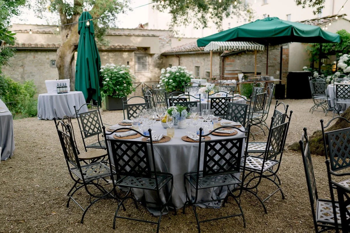 Guests gathered around tables during a welcome dinner inside the restaurant's garden at Torre a Cona wedding venue.