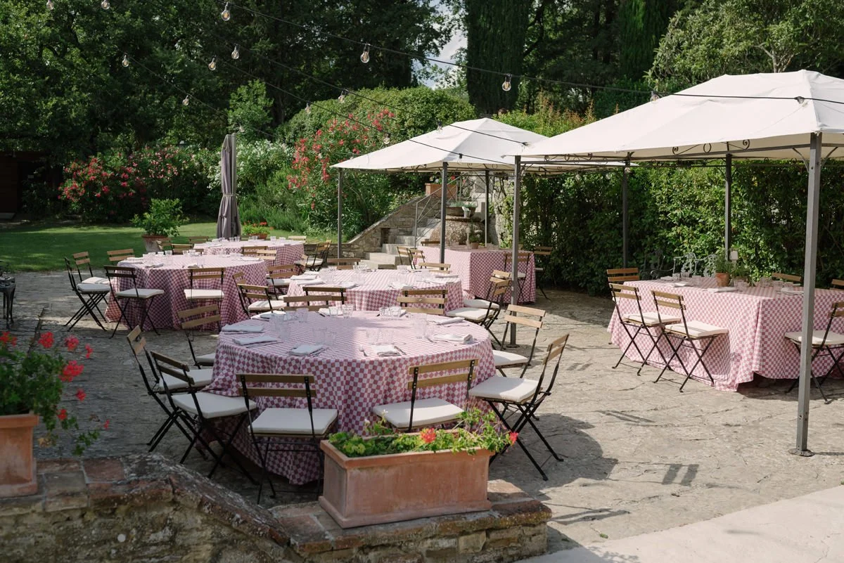 Round table with red and white table covers during the pizza party at Le Filigare wedding venue in Tuscany.