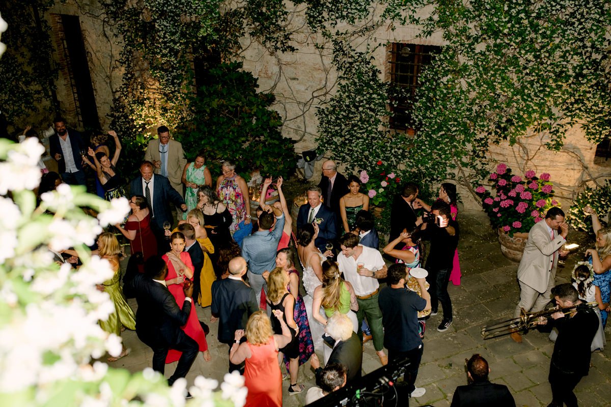 Overhead view of the wedding party in the courtyard of Castello di Bossi during the evening celebration.