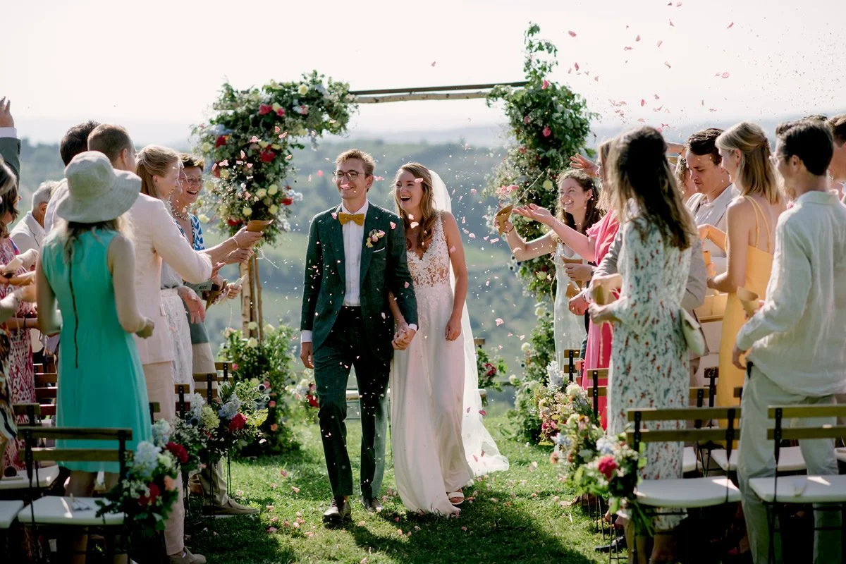 Bride and groom smiling walking from ceremony at Le Filigare wedding venue in Tuscany.