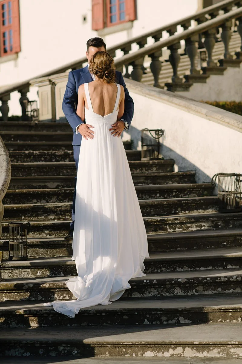 Wedding couple kissing on the stone stairs of Villa Artimino, a historic Medici villa in Tuscany.