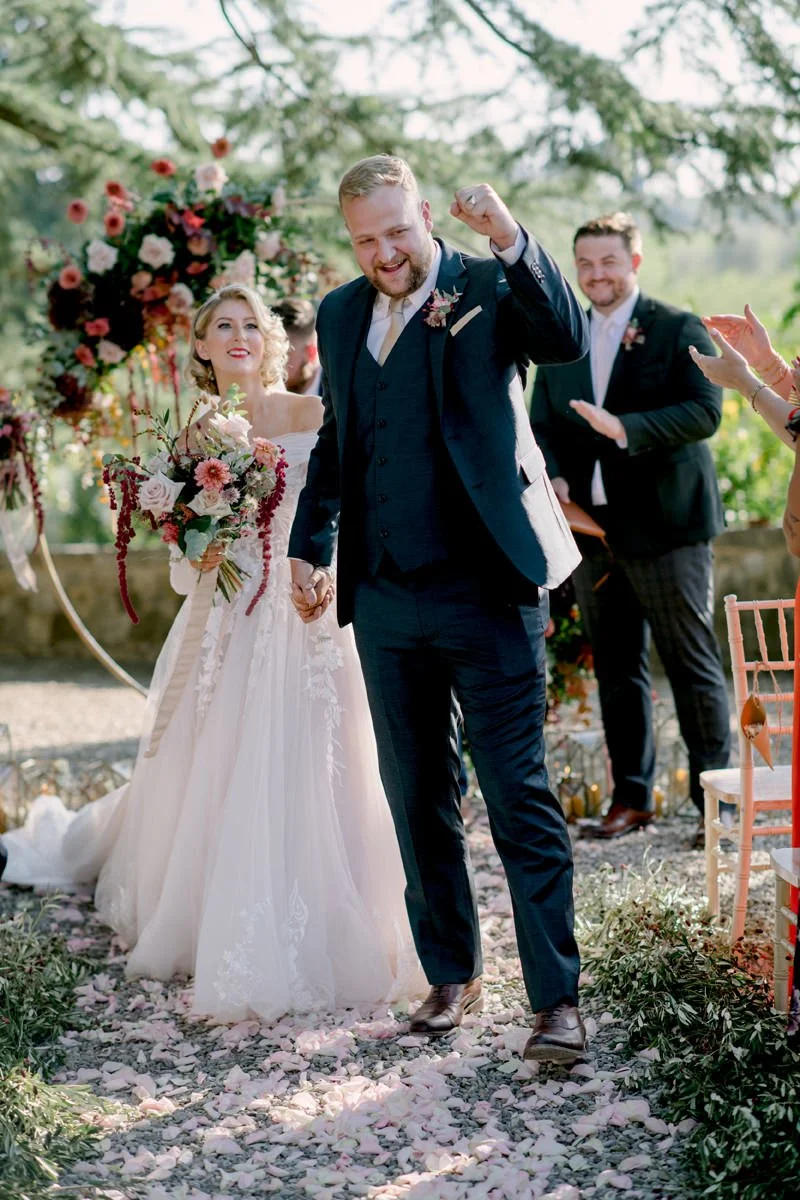 Bride and groom smiling and celebrating together after their wedding ceremony at Castello Il Palagio.