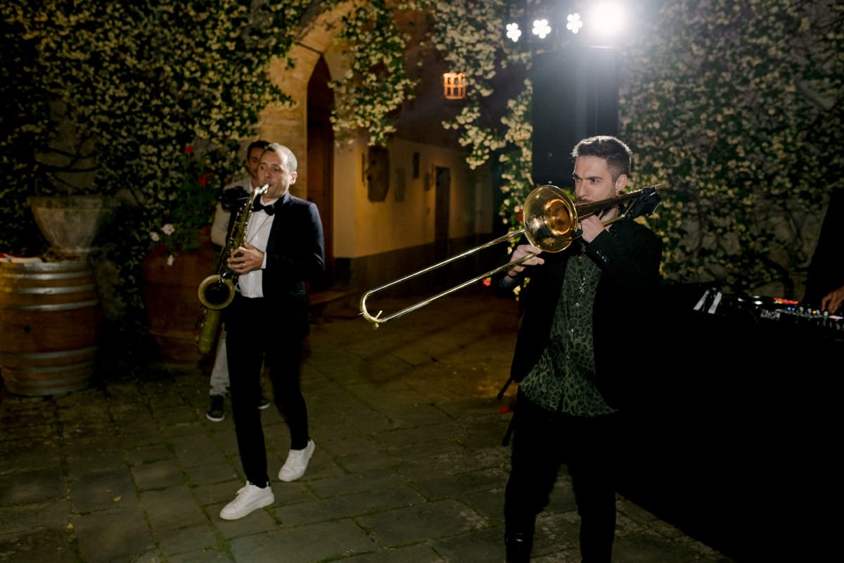 Live musicians playing trumpet and saxophone during the first dance at a Castello di Bossi wedding.