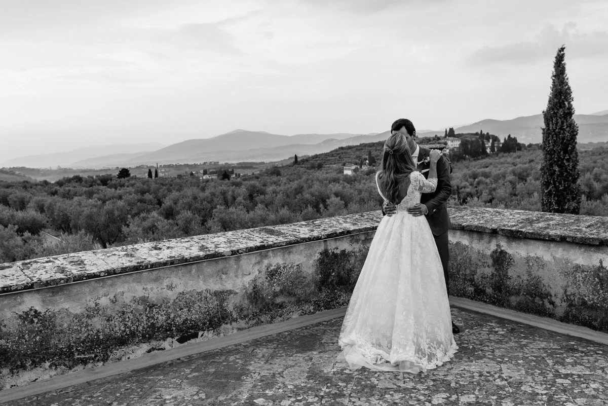 Black and white photo of wedding couple kissing on the terrace of Villa Medicea di Lilliano
