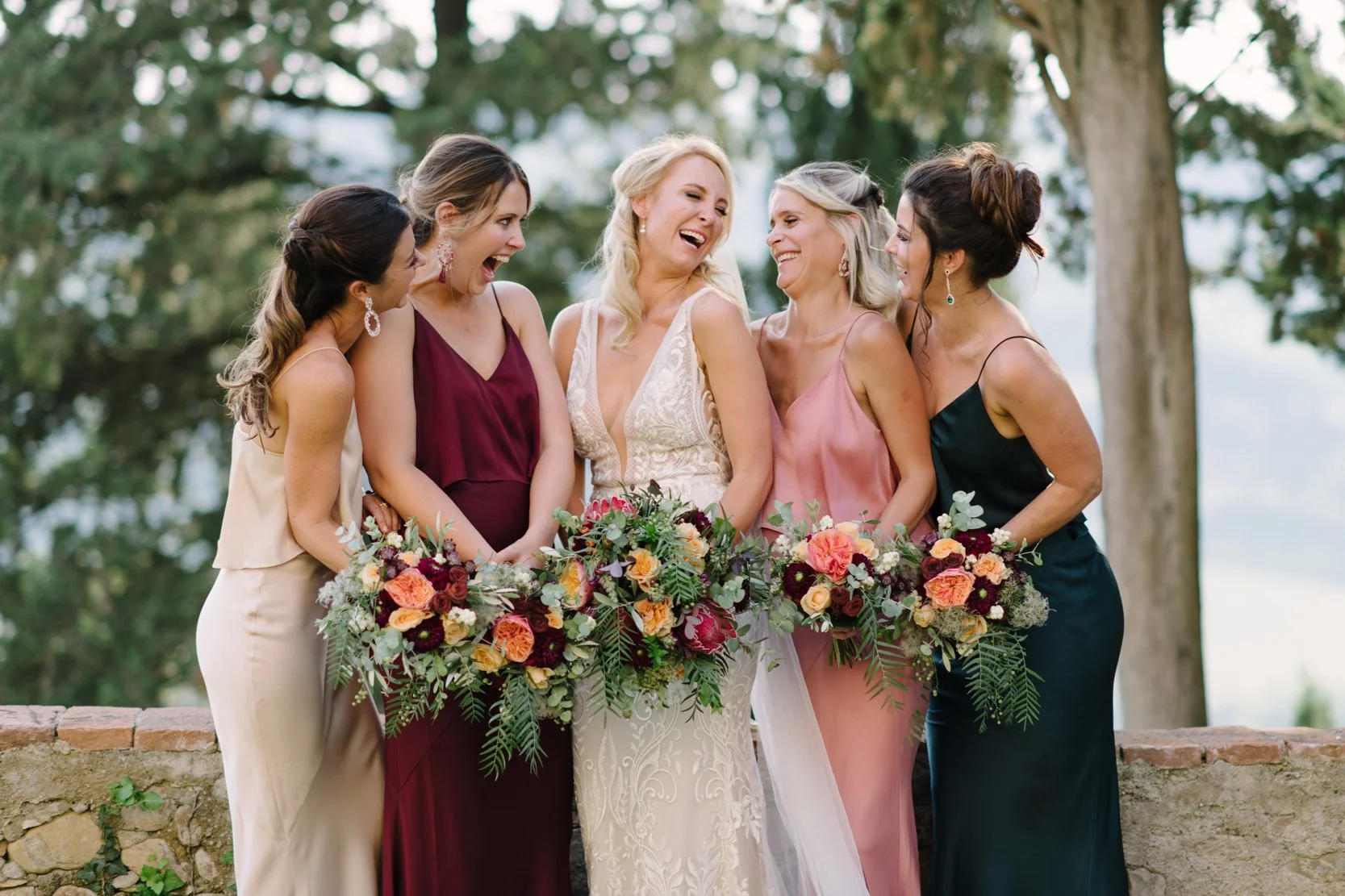Bride laughing with her bridesmaids on her wedding day at Castello di Bibbione in Tuscany, candid moment by FunkyBird Photography