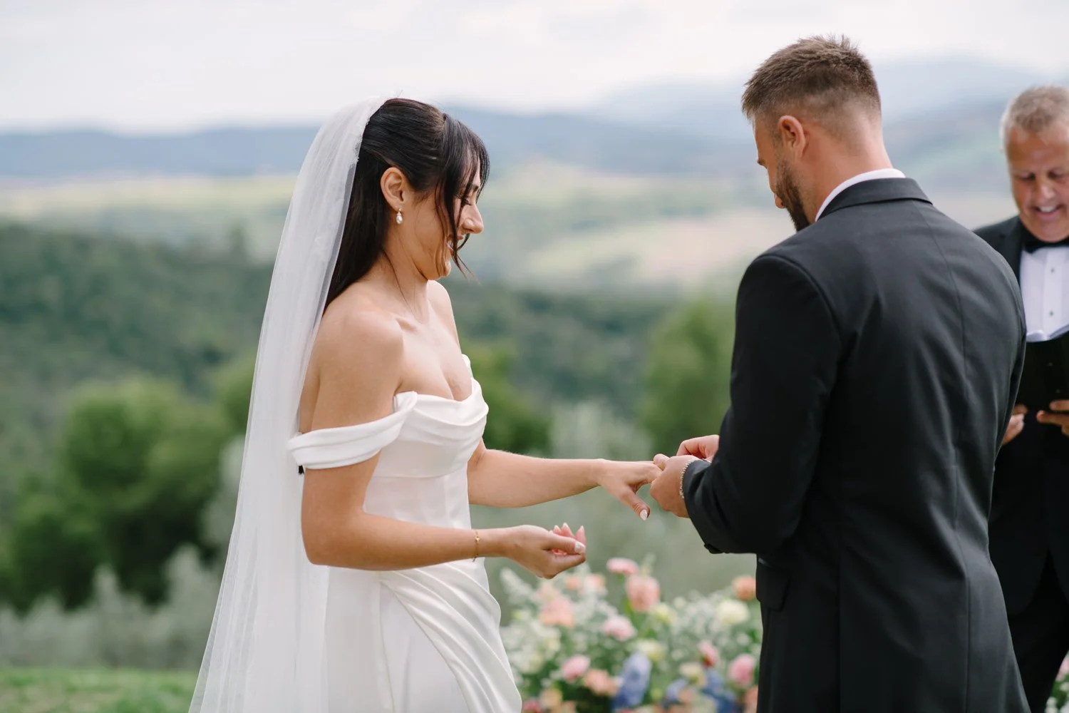 Bride and groom exchanging rings during their symbolic ceremony at Villa di Ulignano, by FunkyBird