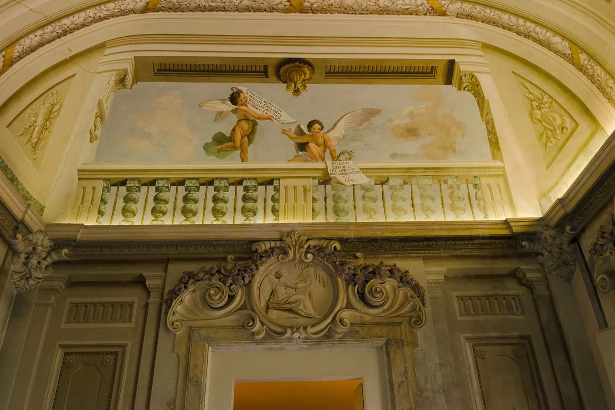 Historic ballroom at Castello di Montegufoni with original frescoed walls, photographed during a wedding celebration in Tuscany.
