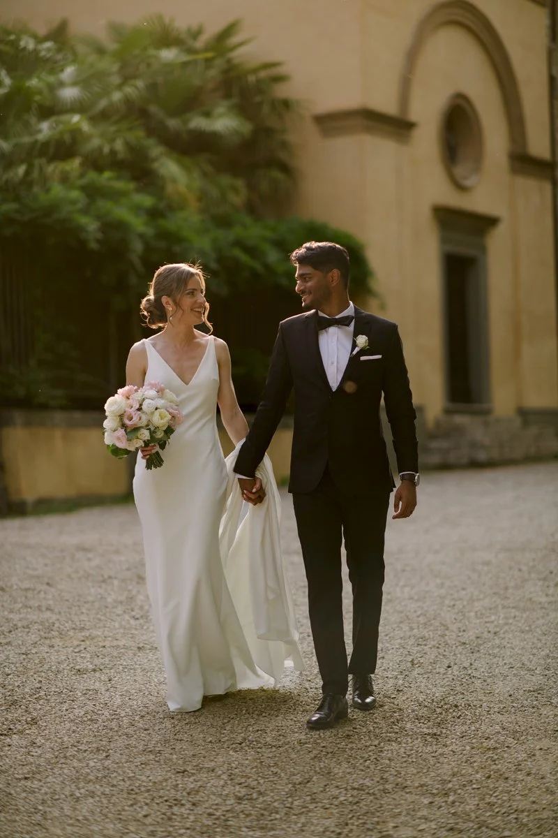 Couple walking during golden hour in front of the small church at Tenuta di Monaciano in Tuscany.