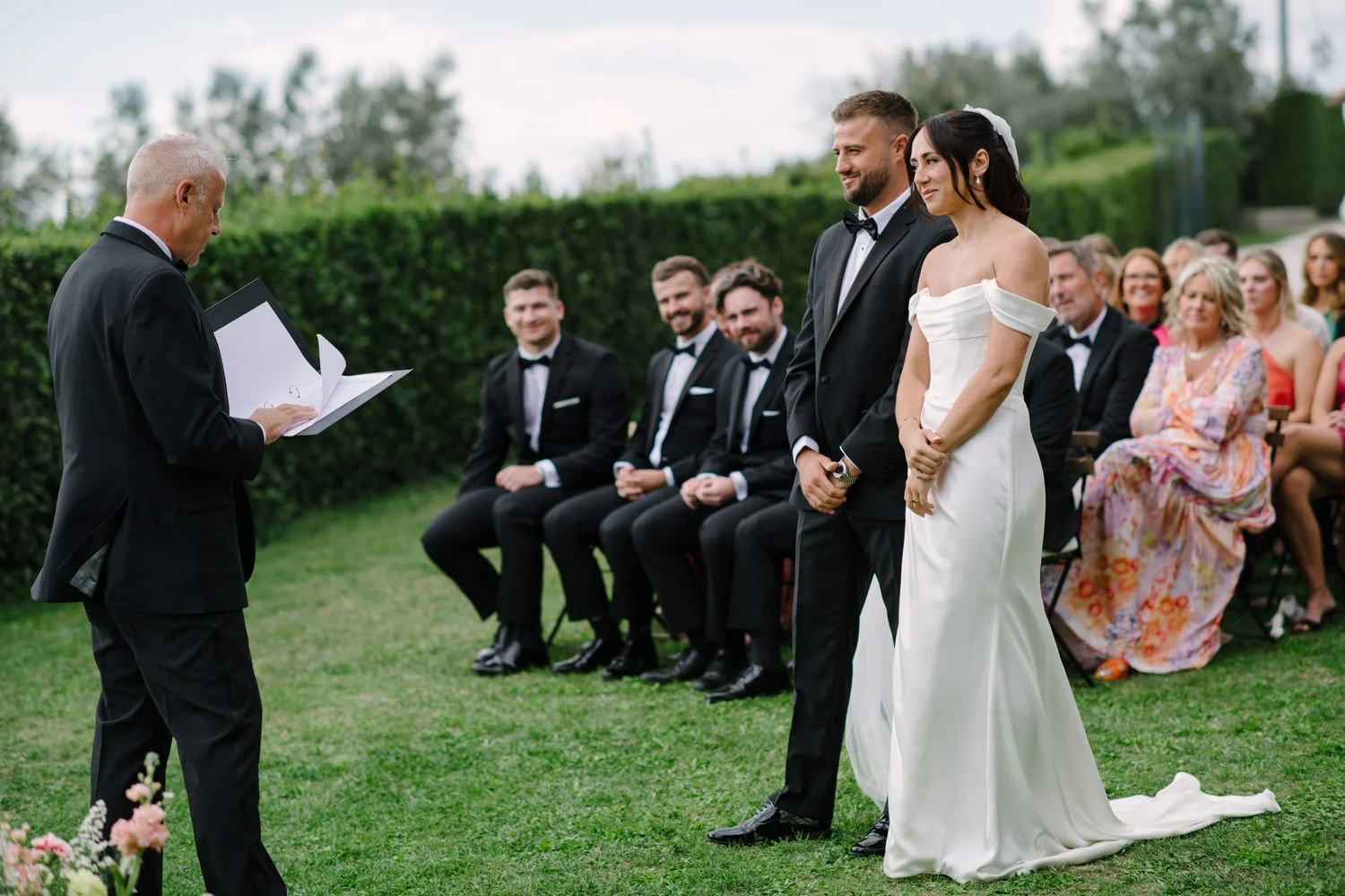 Bride and groom standing before their family officiant during the symbolic ceremony at Villa di Ulignano