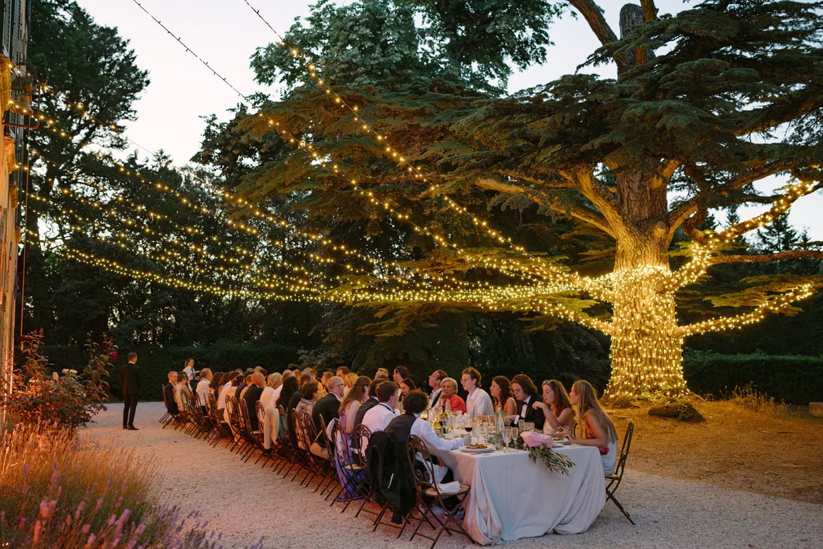 Wedding dinner at the back garden of Villa di Ulignano, set under string lights around the large tree for an atmospheric evening reception.