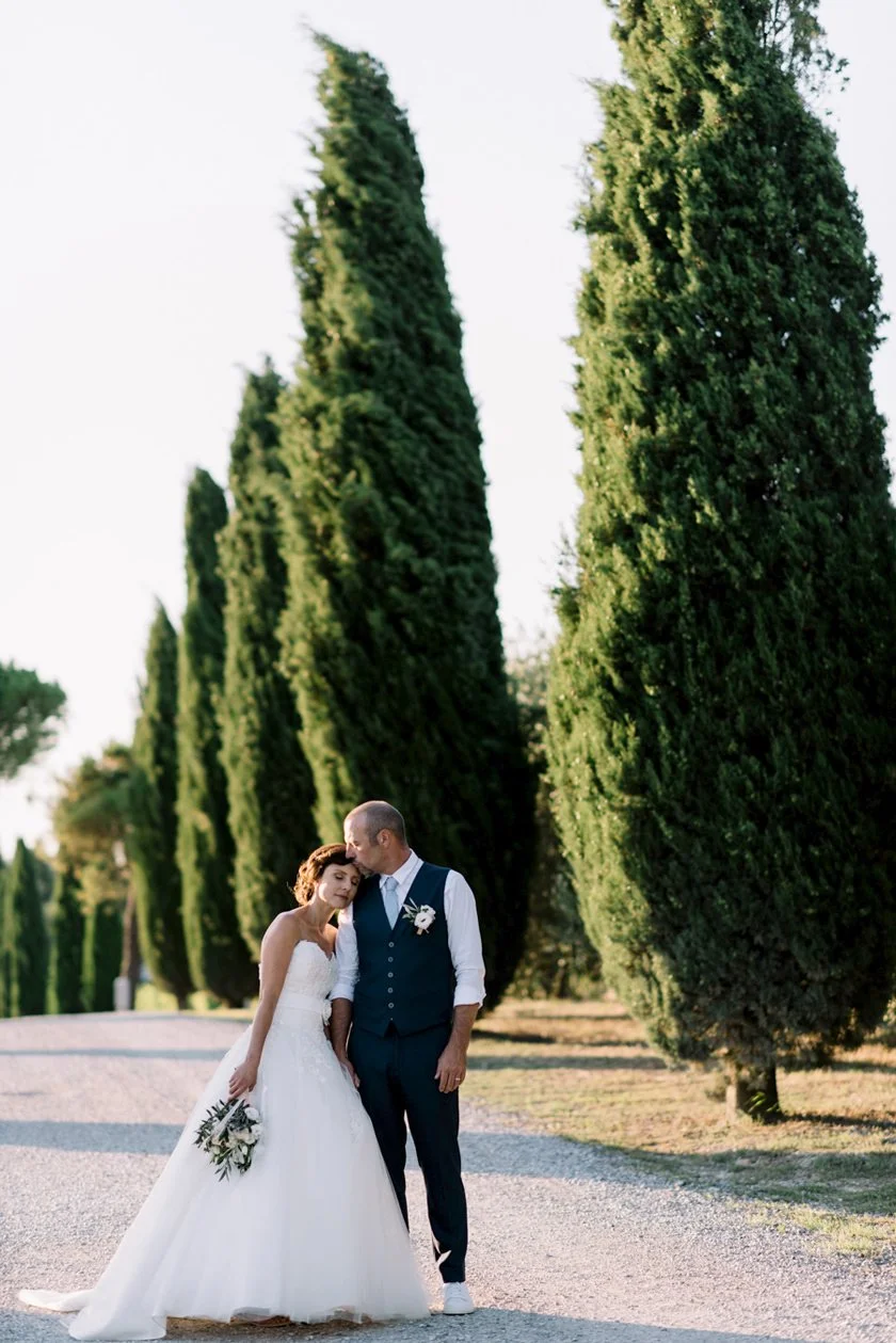 Couple standing close together in the cypress-lined alley at Terre di Nano wedding venue in Val d’Orcia.