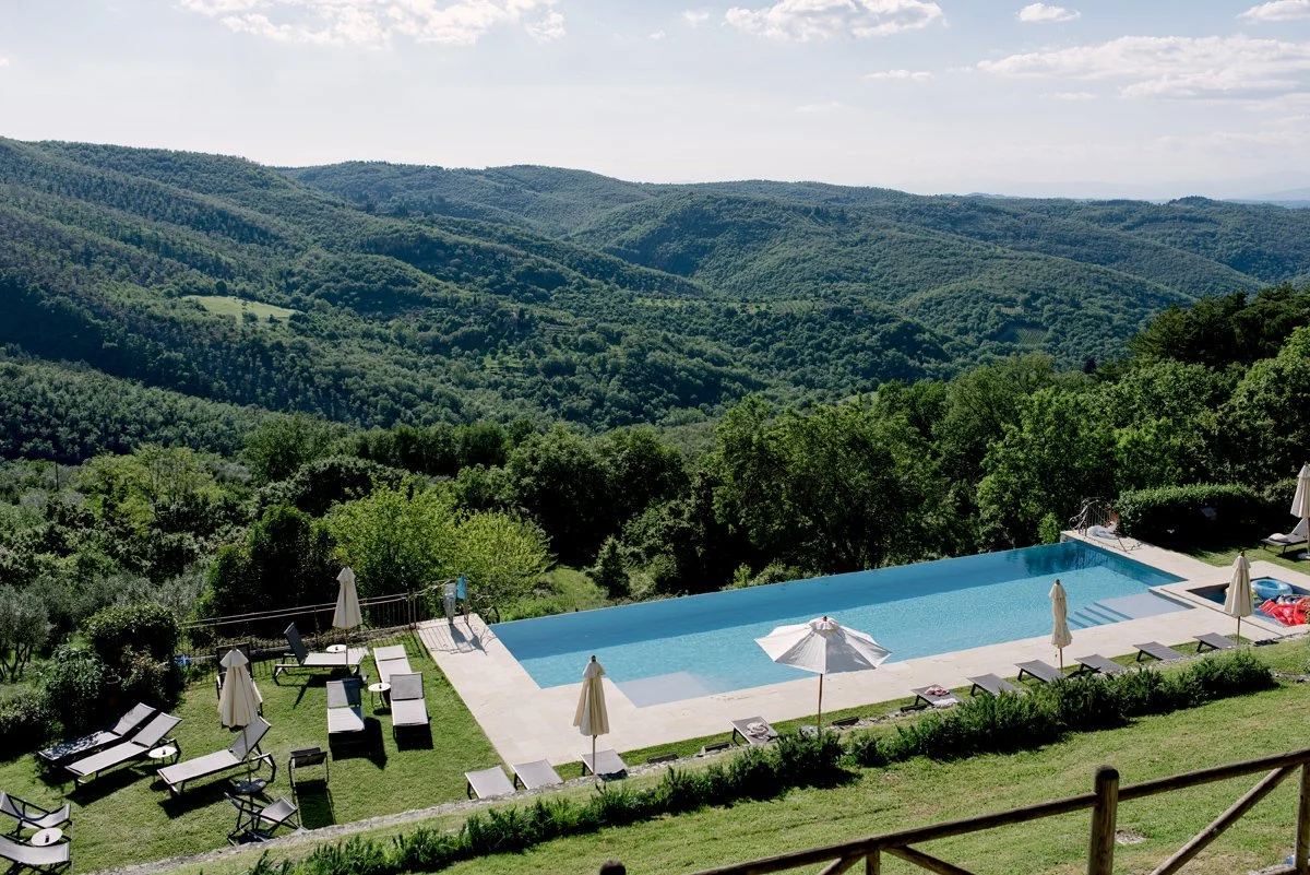 Swimming pool at Borgo Pietrafitta surrounded by forests and Tuscan countryside.