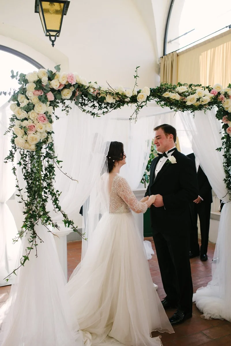 Bride and groom during their wedding ceremony on the terrace under the cupola at Villa Hotel Tolomei overlooking Florence.