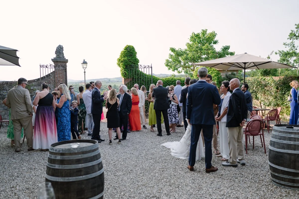 Wedding guests enjoying aperitivo in one of the gardens at Castello di Bossi wedding venue in Tuscany.