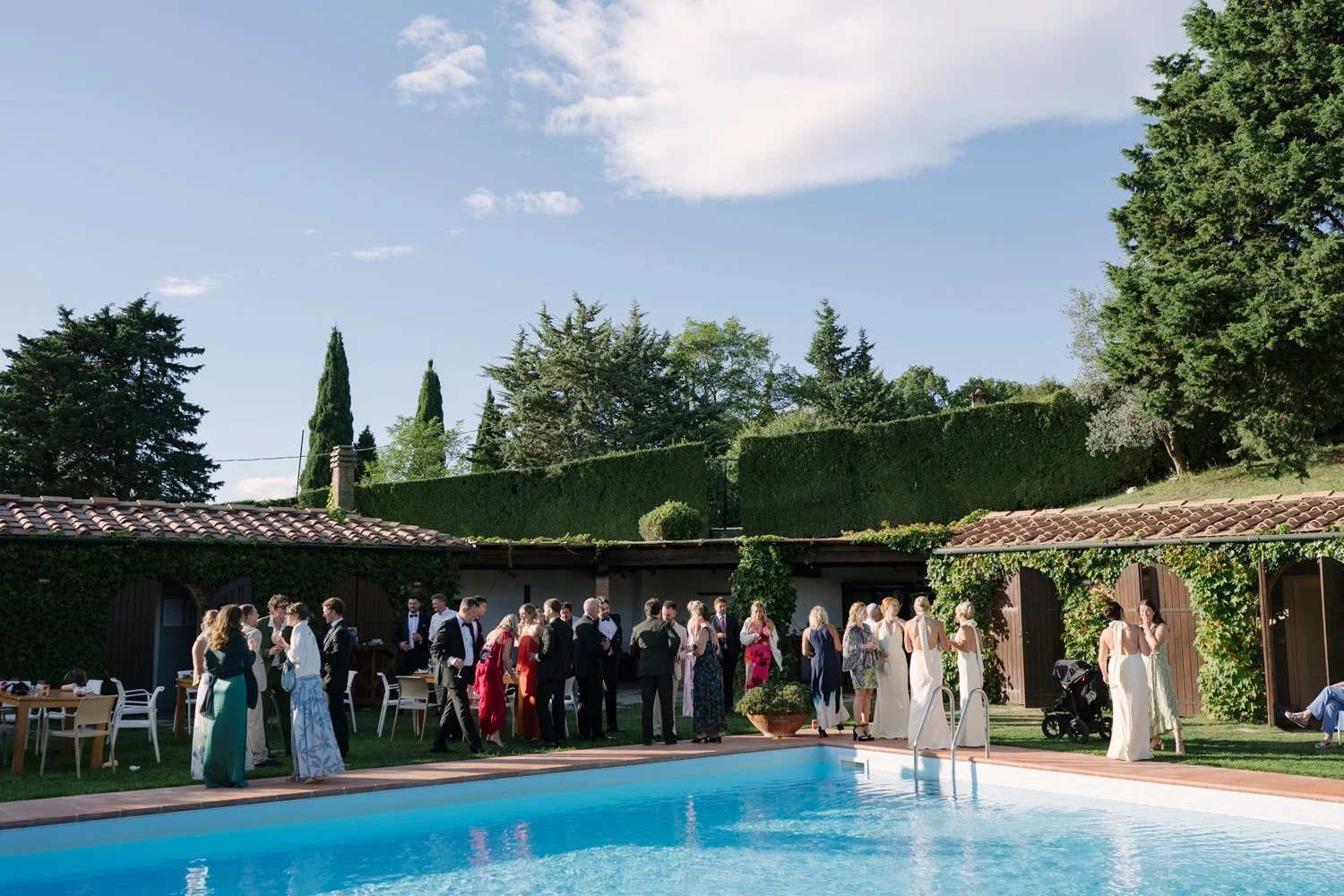 Wedding aperitivo by the pool at Villa di Ulignano with guests overlooking the Tuscan countryside, by FunkyBird