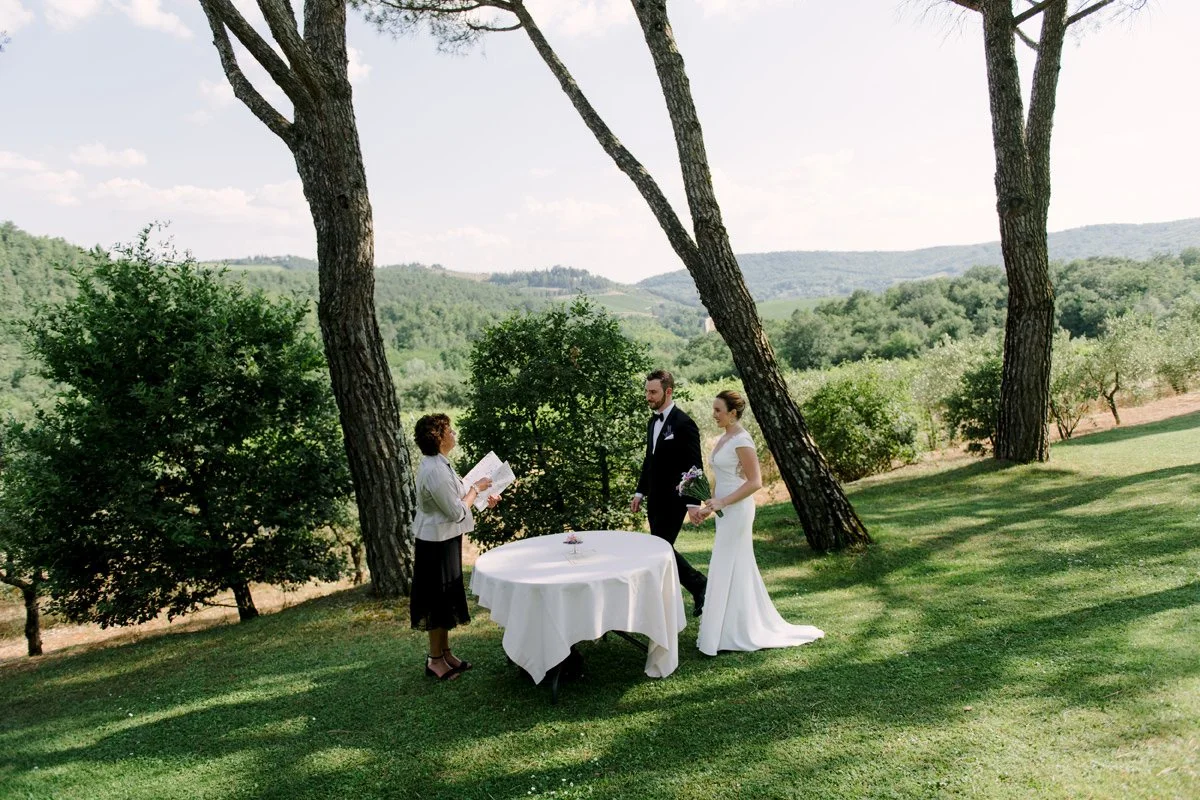 Elopement ceremony at Castello di Spaltenna held under large mature trees in a secluded outdoor setting.