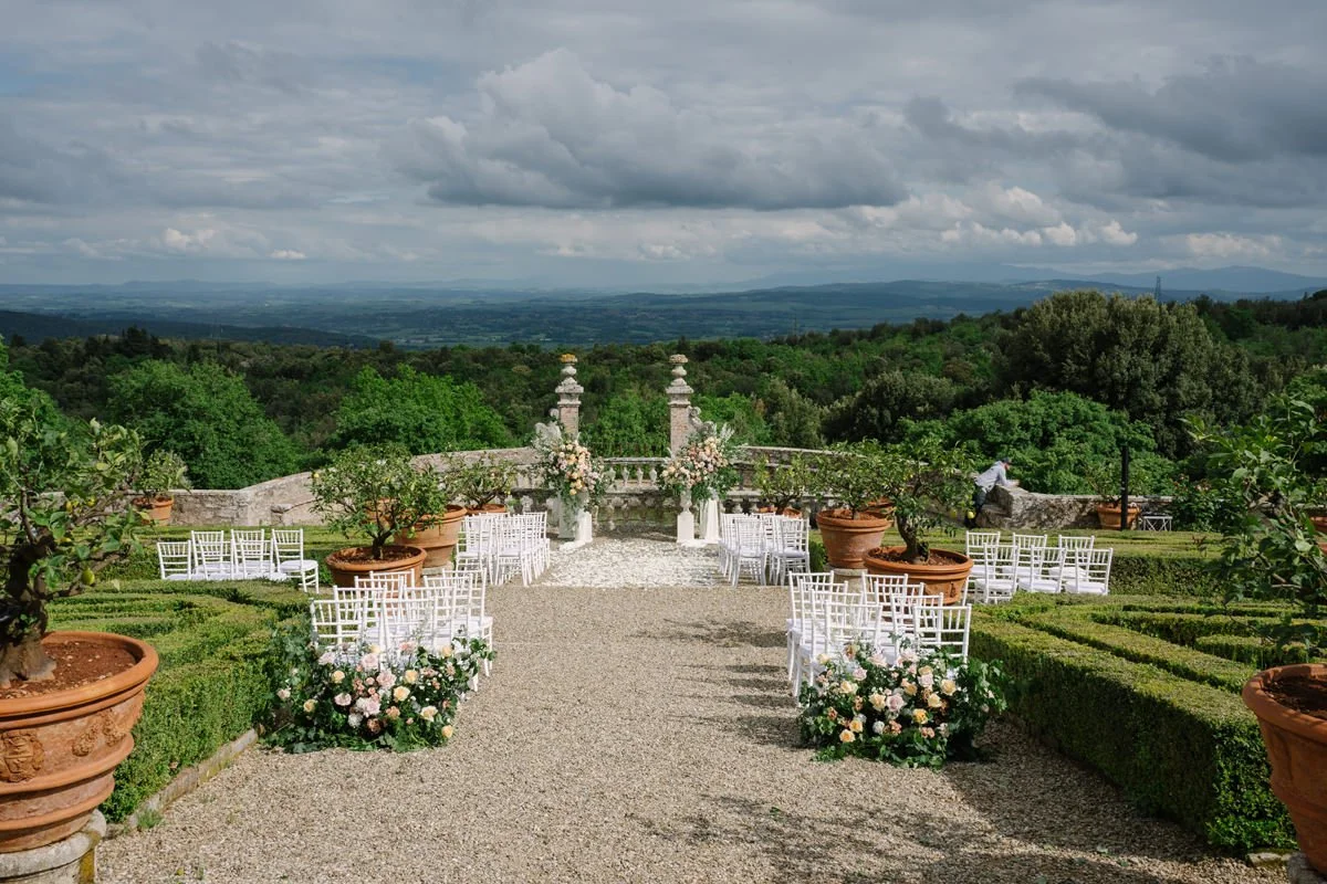 Outdoor wedding ceremony setup at Castello di Celsa with stunning florals and scenic views
