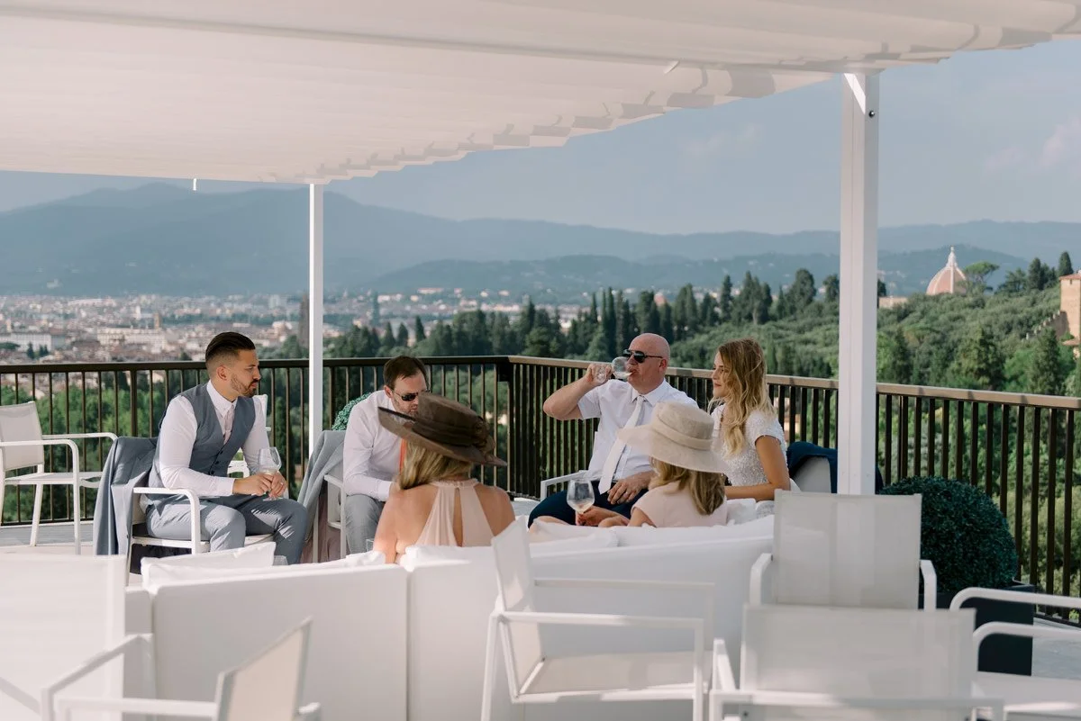 Wedding guests seated on the rooftop terrace at Villa Cora during aperitivo, overlooking Florence.