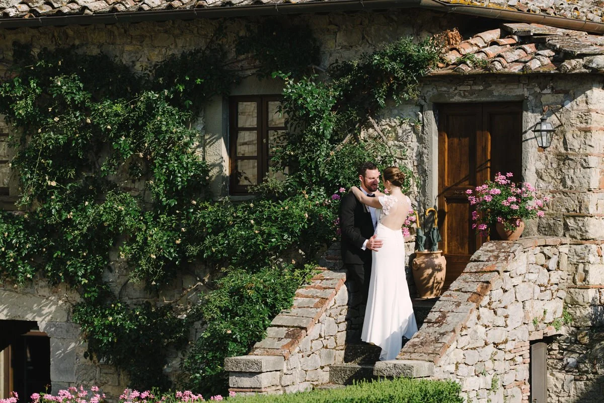 Couple kissing on the stone stairs of an apartment building at Castello di Spaltenna wedding venue.