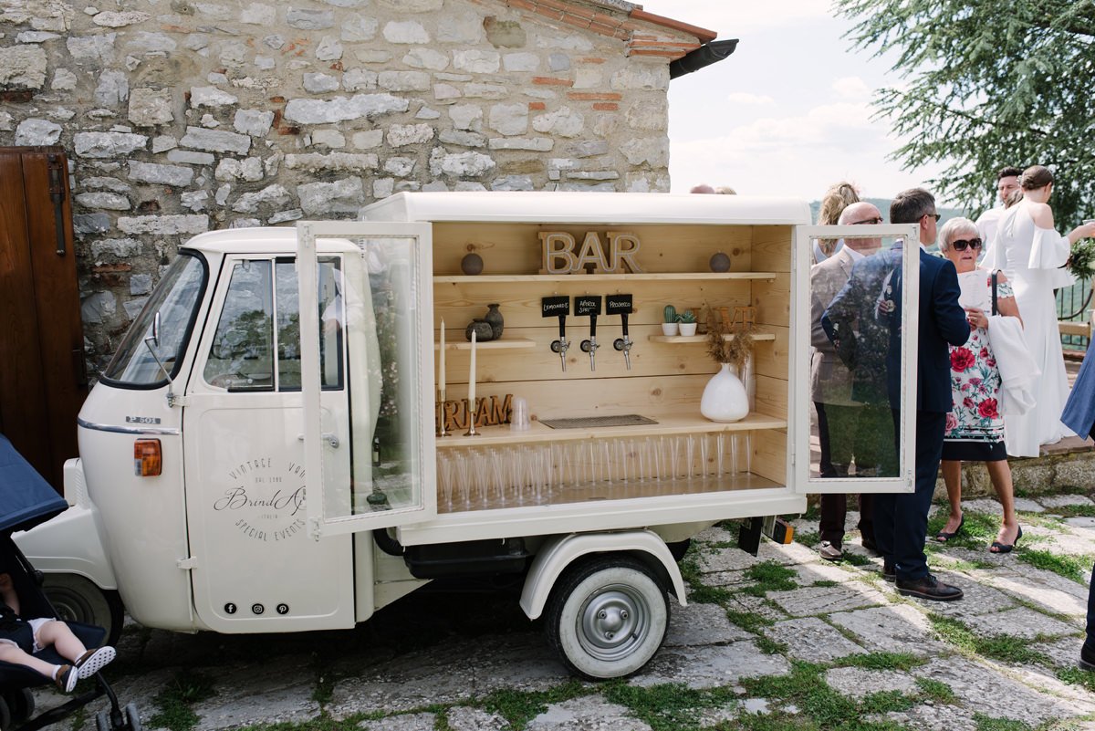 Small Italian Ape vehicle serving prosecco drinks during a wedding celebration at Borgo Pietrafitta.