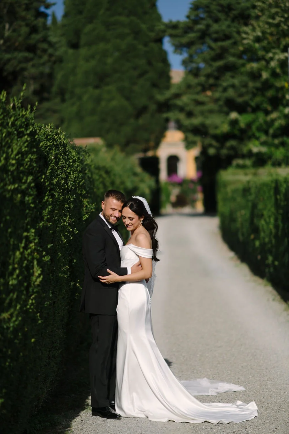 Intimate moment between bride and groom against the villa's terracotta wall at Villa di Ulignano, by FunkyBird