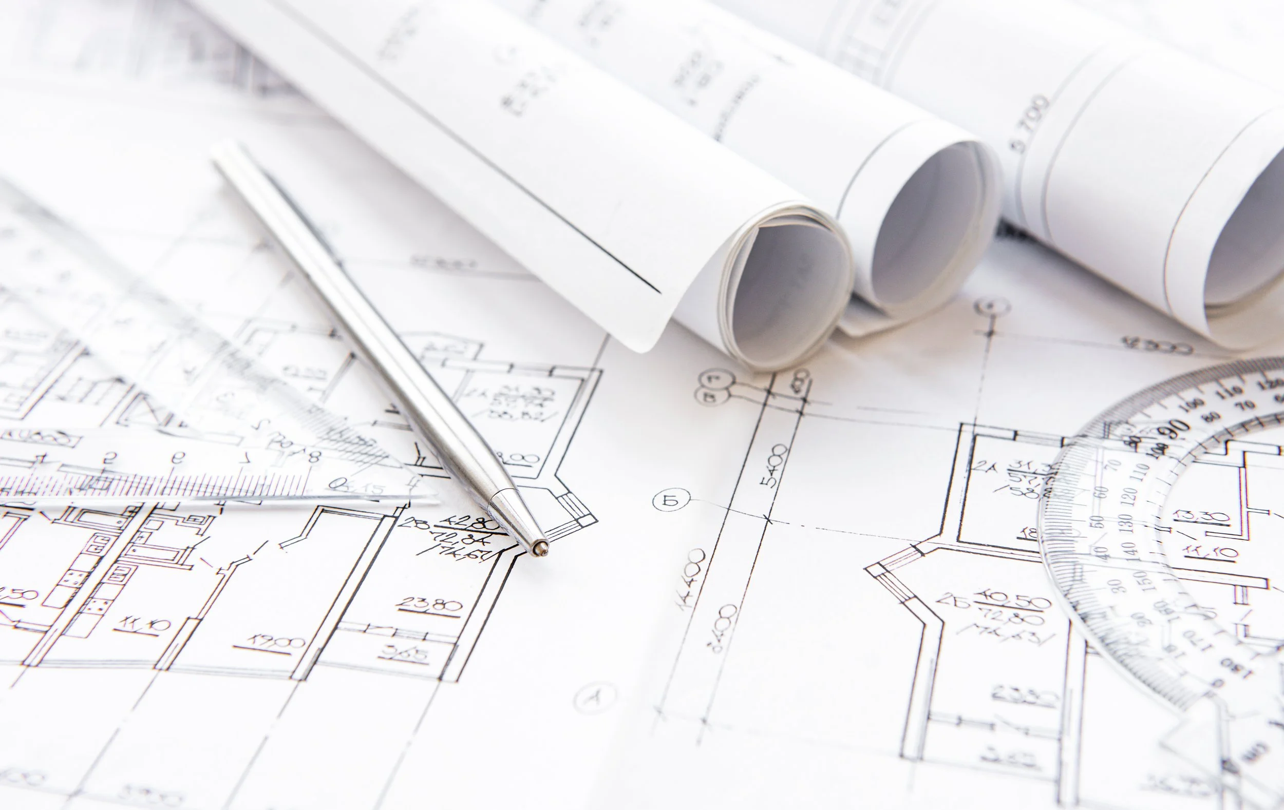 Architectural blueprints and rolled construction plans for a luxury kitchen remodel project during the design and pre-construction planning phase in Fullerton, California by Apex Construction & Restoration Inc.