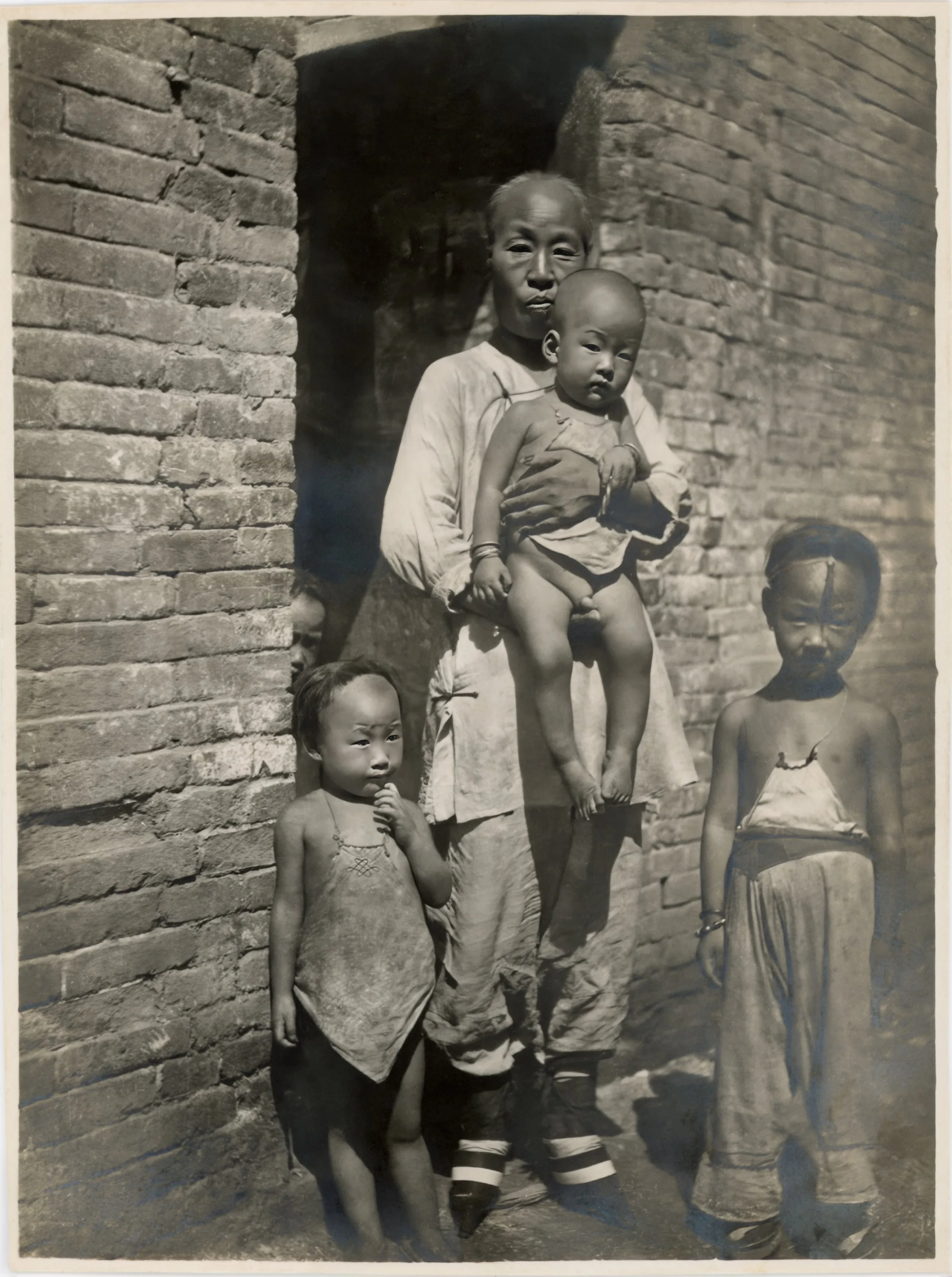 A woman poses with her family in front of a brick building.