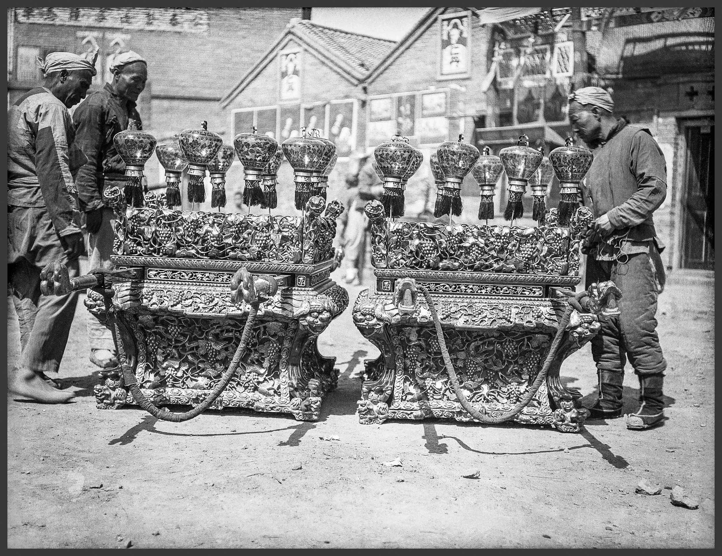 Three men are looking at large portable and ornate shrines.