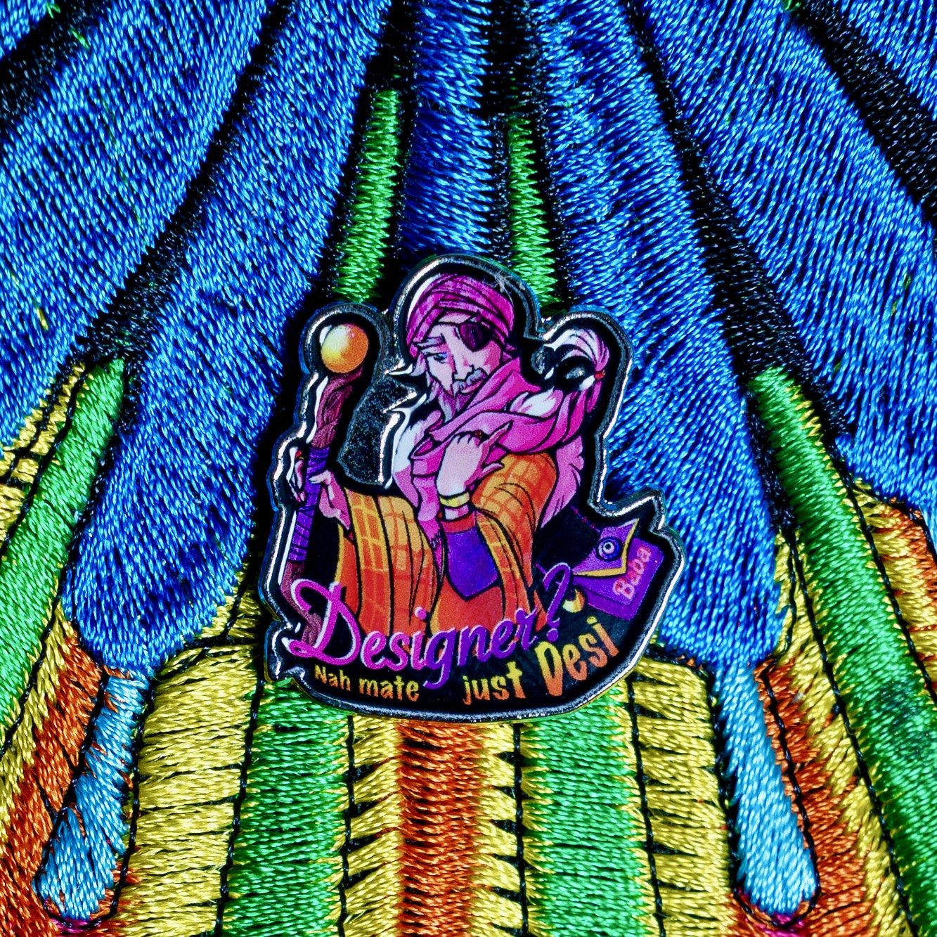 Enamel Lapel Pin featuring baba Desi, The Belgrave Wizard with the caption 'Designer? Nay mate just Desi'