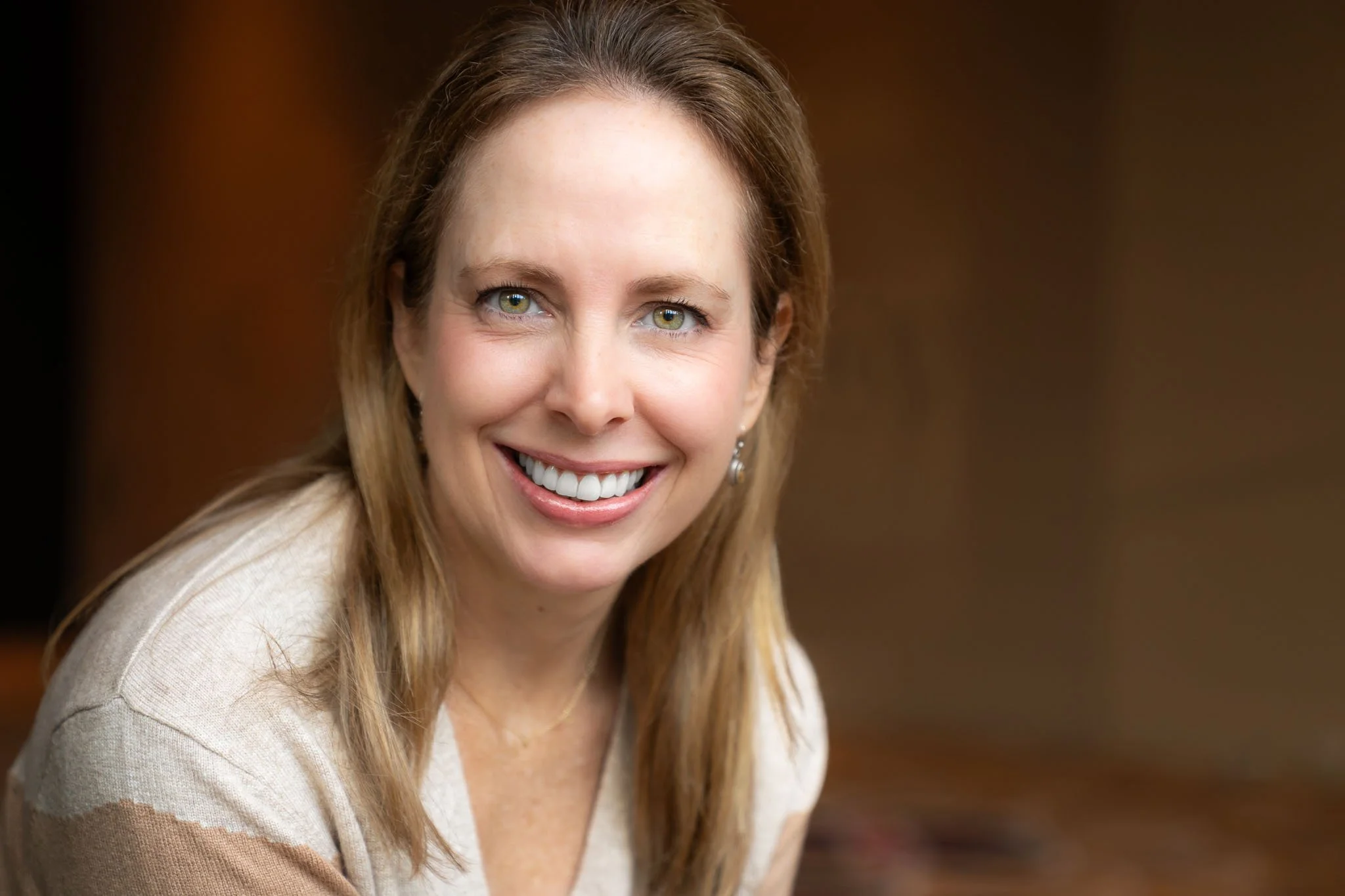 A corporate  headshot showing a relaxed and approachable career woman