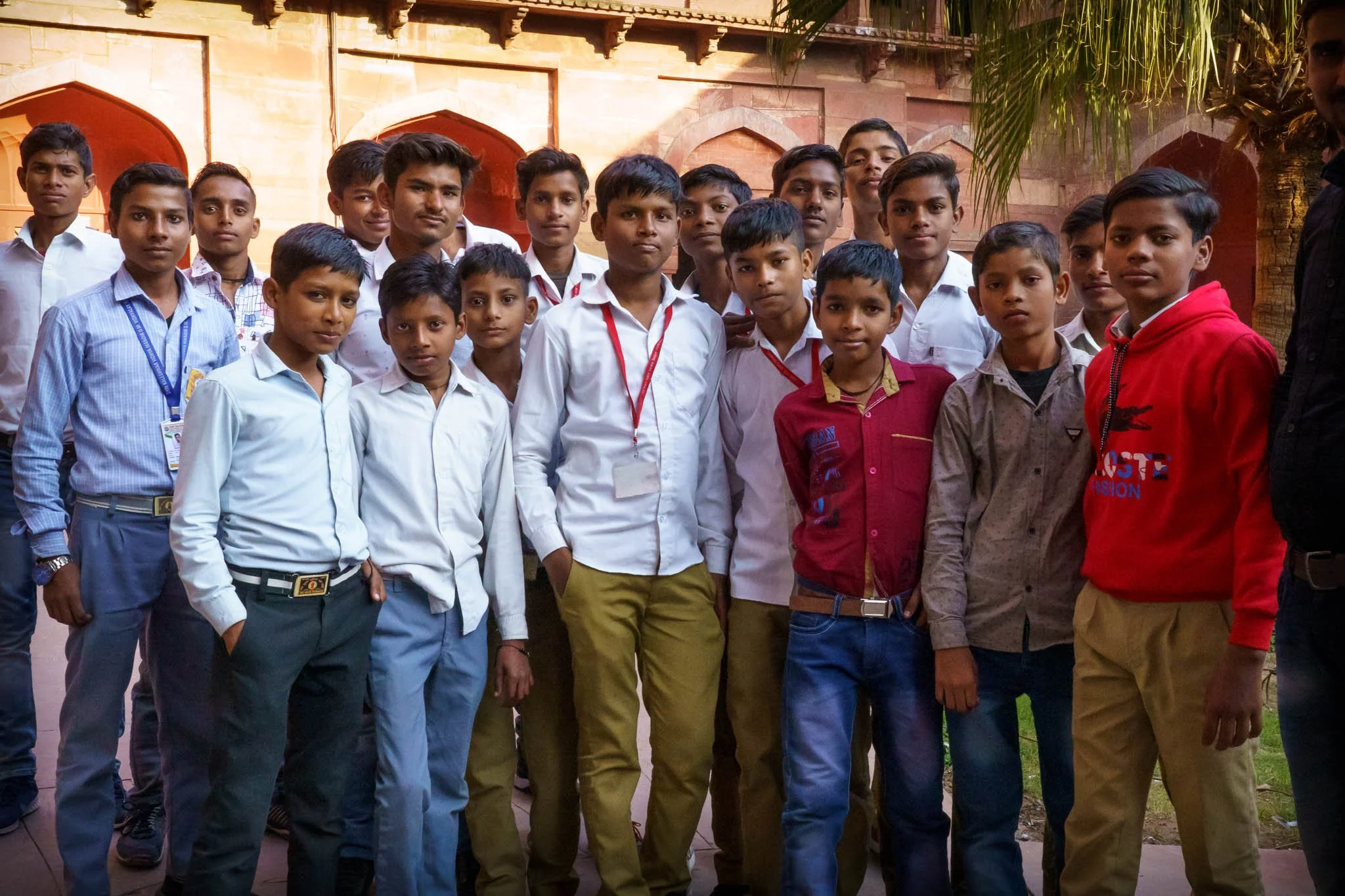 Young Indian schoolboys in smart school uniforms stand close together at Agra Fort