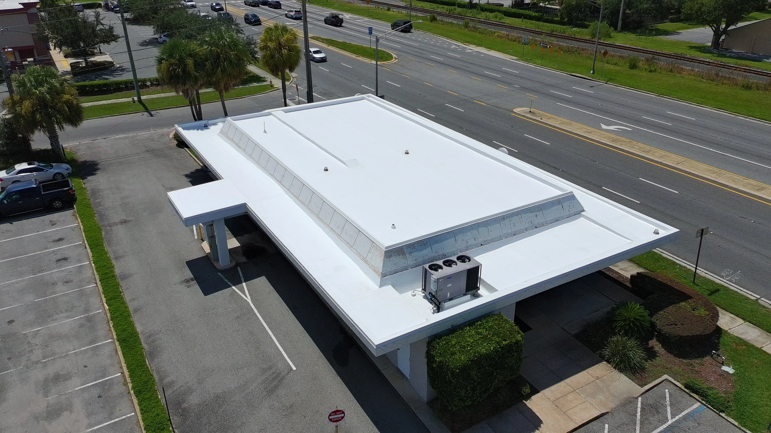 Commercial TPO re-roof completed for an operating bank over an existing modified roofing system, featuring a new fully adhered membrane, perimeter metal, and associated accessories for long-term performance and weather protection.