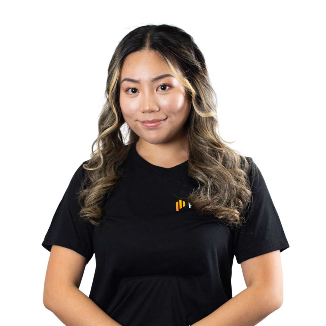 A young woman with long wavy hair, wearing a black t-shirt with a logo, smiling and looking at the camera.