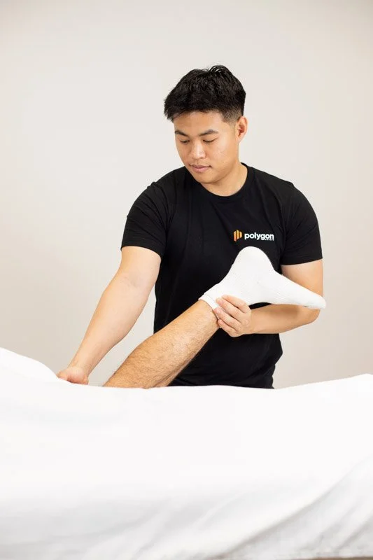 A woman providing neck therapy to a man lying on a chiropractic table.