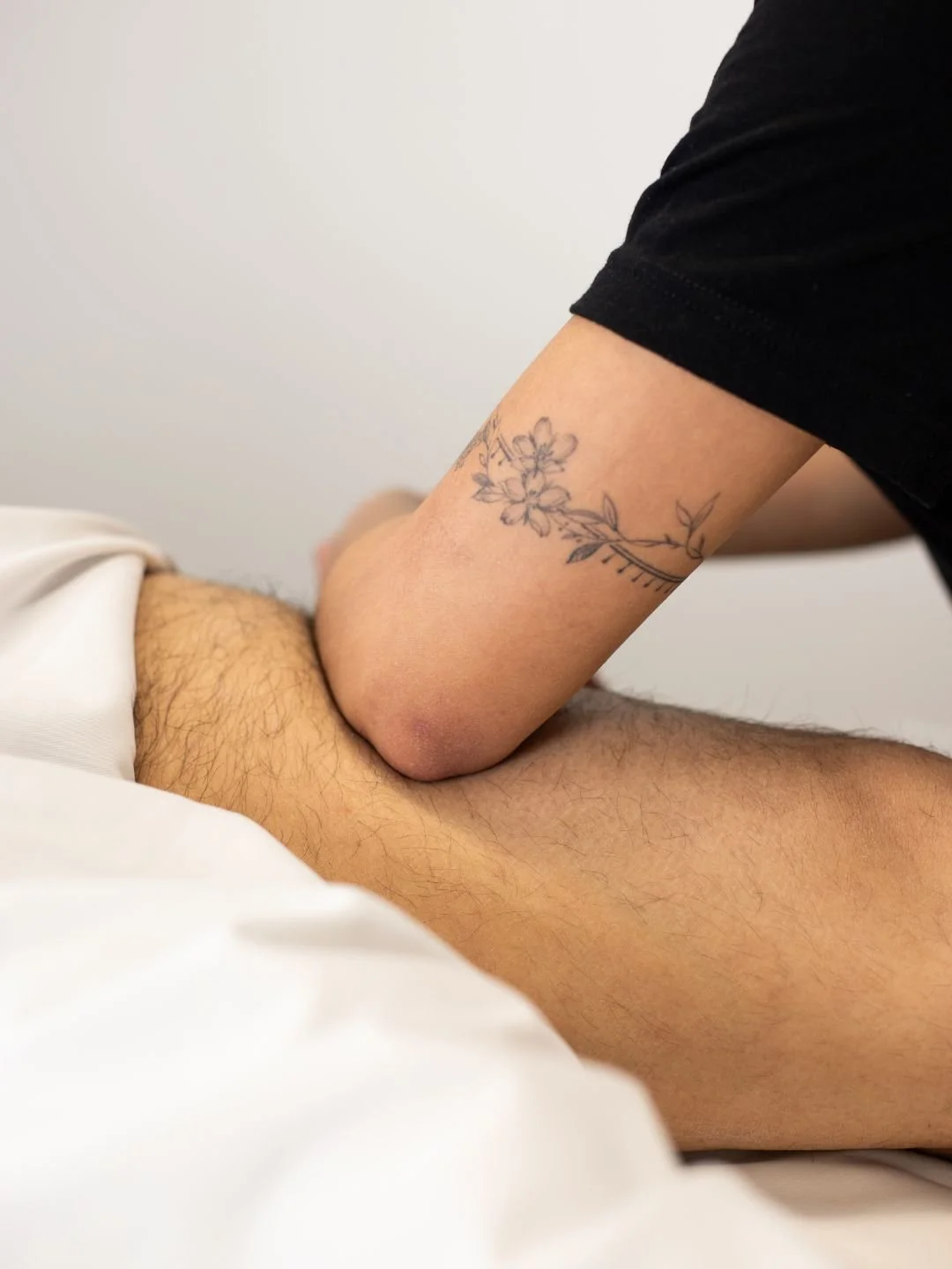 Physical therapist assisting a patient with leg exercises on a pilates reformer machine