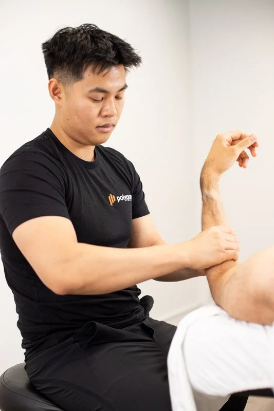 Physical therapist assisting a patient with leg exercises on a pilates reformer machine