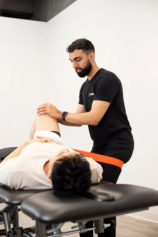 A woman providing neck therapy to a man lying on a chiropractic table.