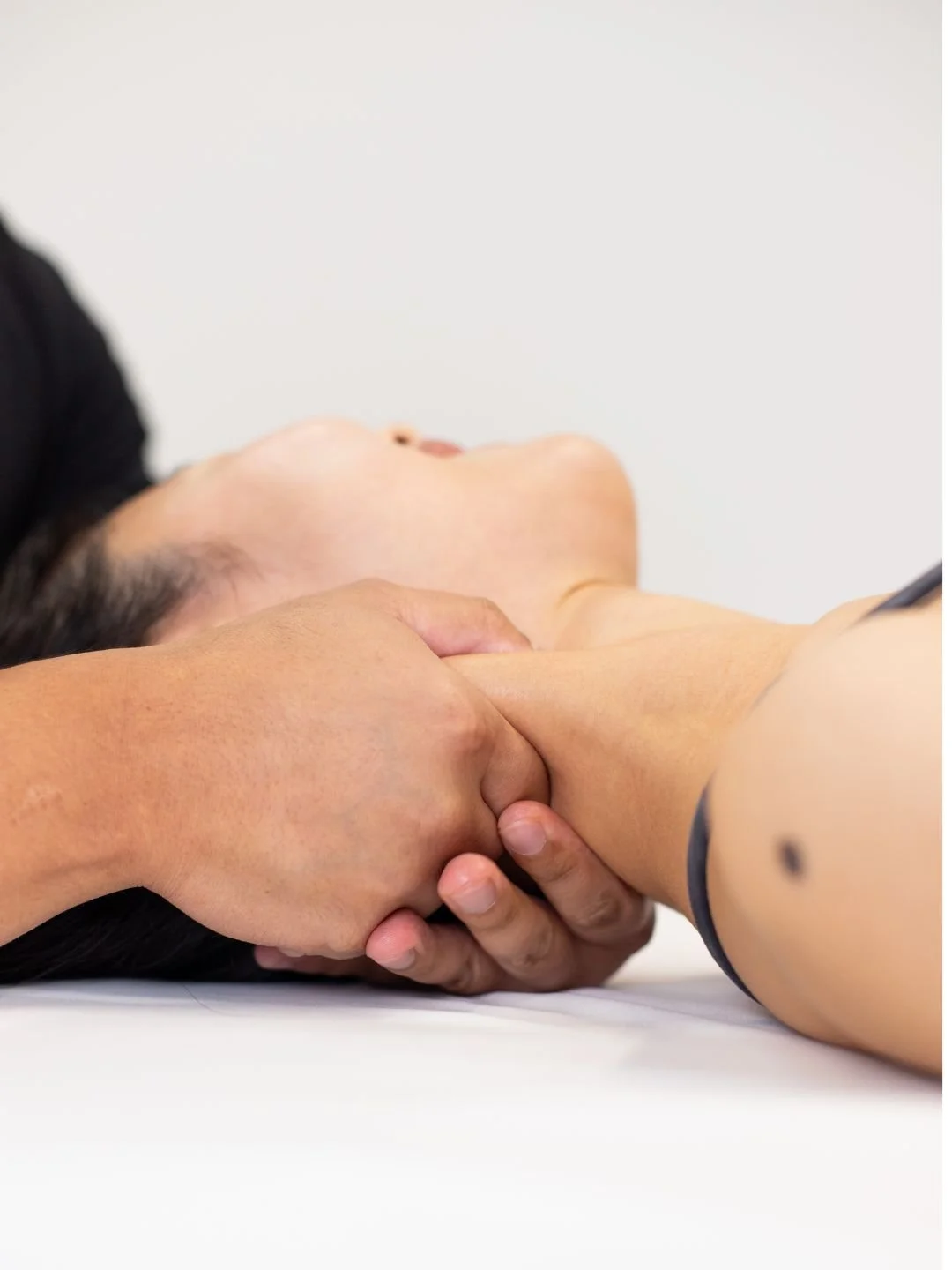 Physical therapist assisting a patient with leg exercises on a pilates reformer machine