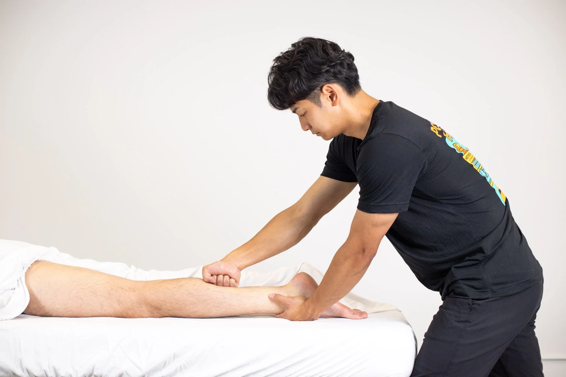 A woman providing neck therapy to a man lying on a chiropractic table.