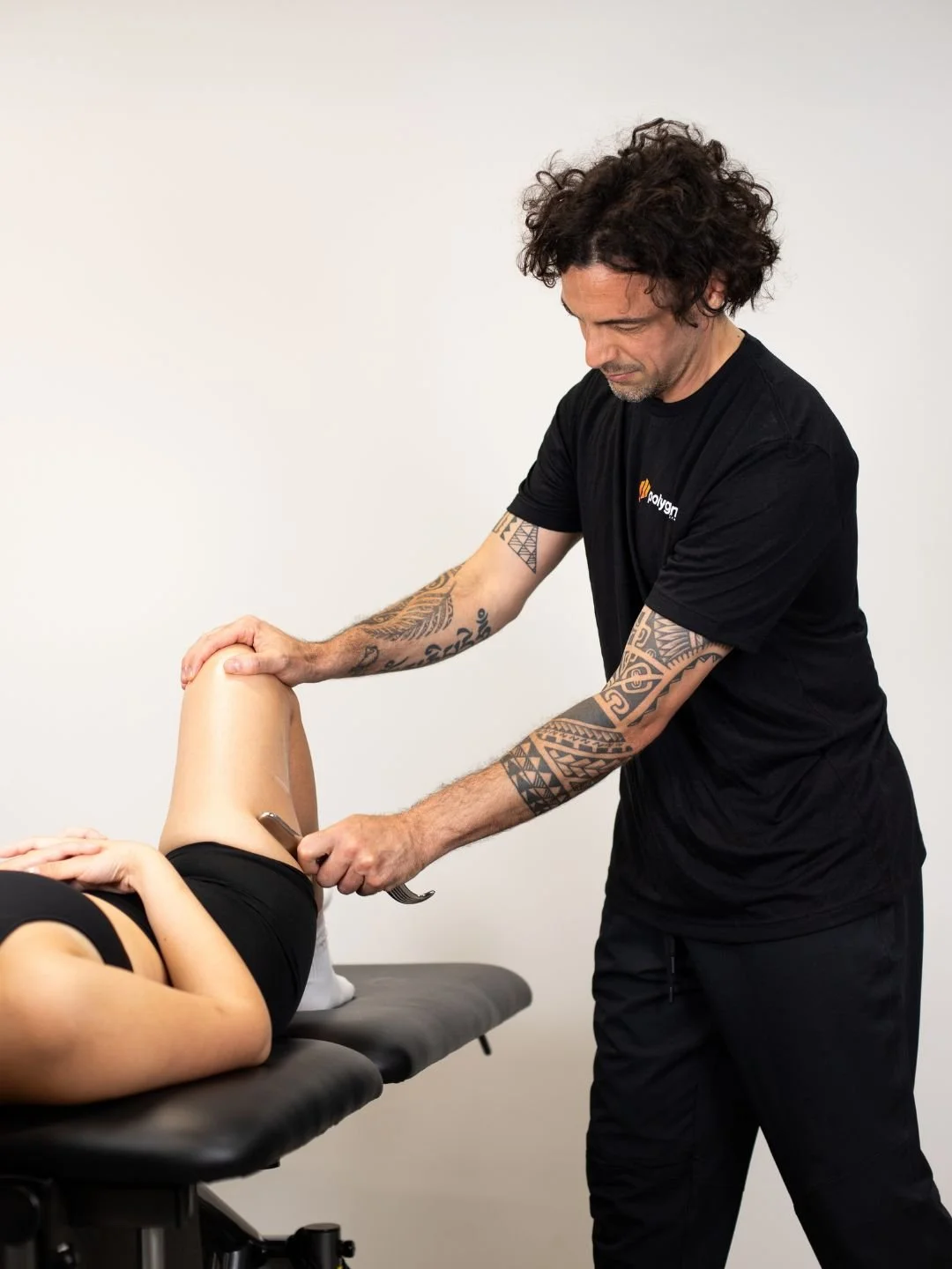 Physical therapist assisting a patient with leg exercises on a pilates reformer machine