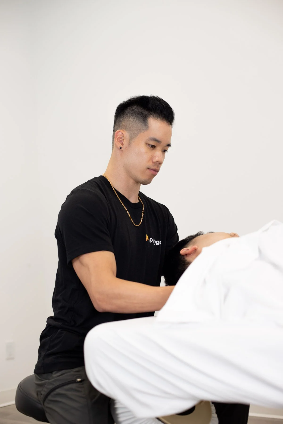Physical therapist assisting a patient with leg exercises on a pilates reformer machine
