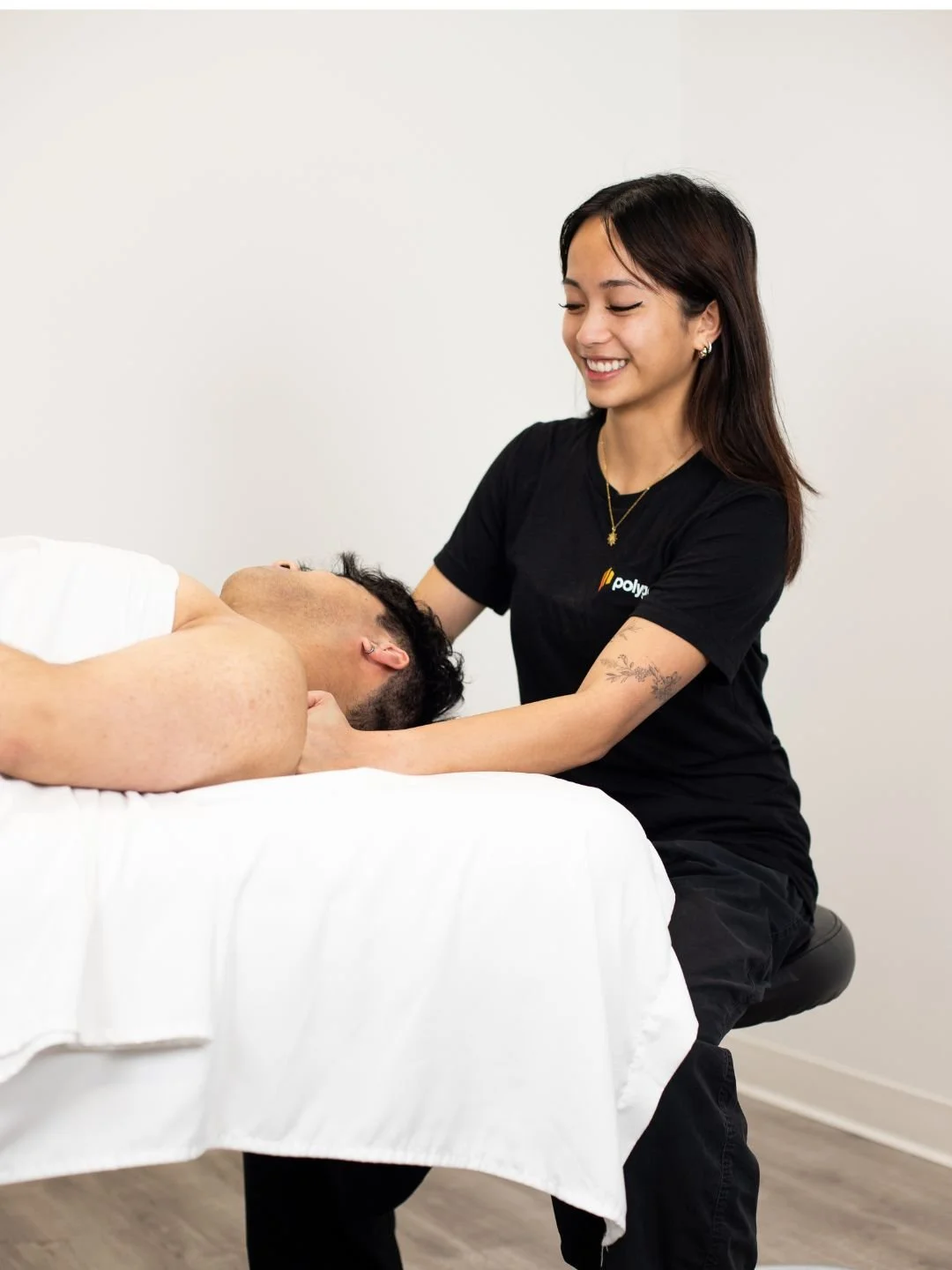 A woman providing neck therapy to a man lying on a chiropractic table.