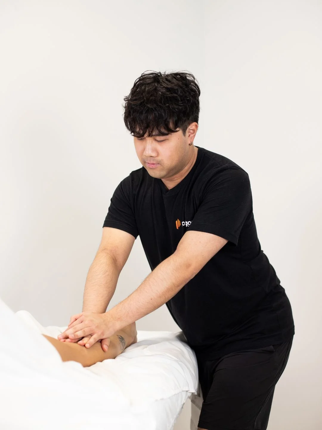 A woman providing neck therapy to a man lying on a chiropractic table.