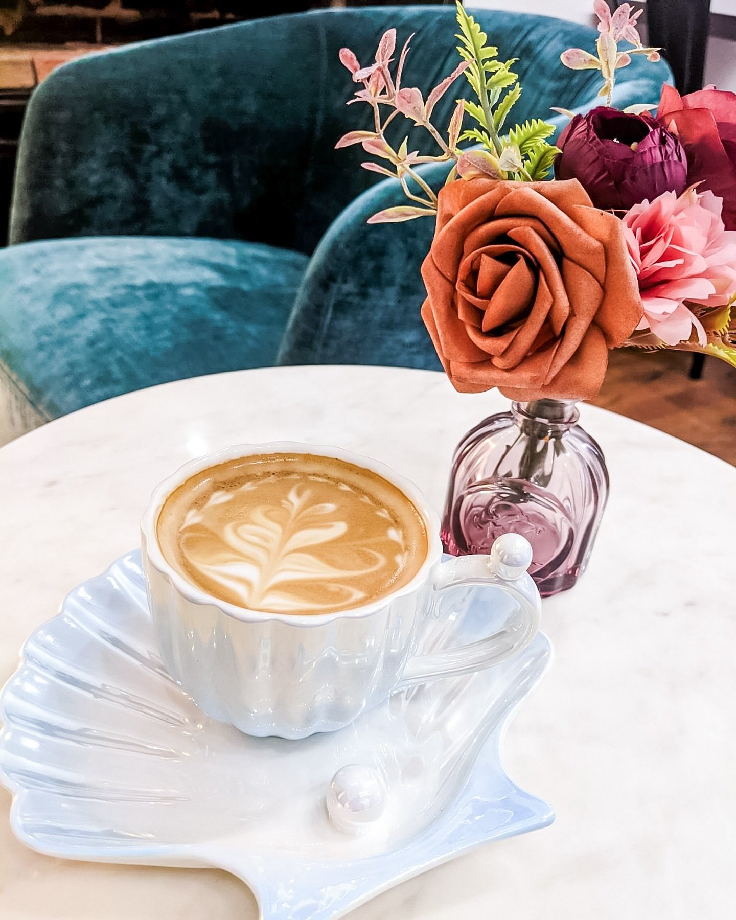 An artfully crafted latte, perfectly paired with a cozy corner and a touch of elegance. 🌸✨Come indulge at TCS! ☕️💐

#LatteArt #CoffeeLovers #cafevibes