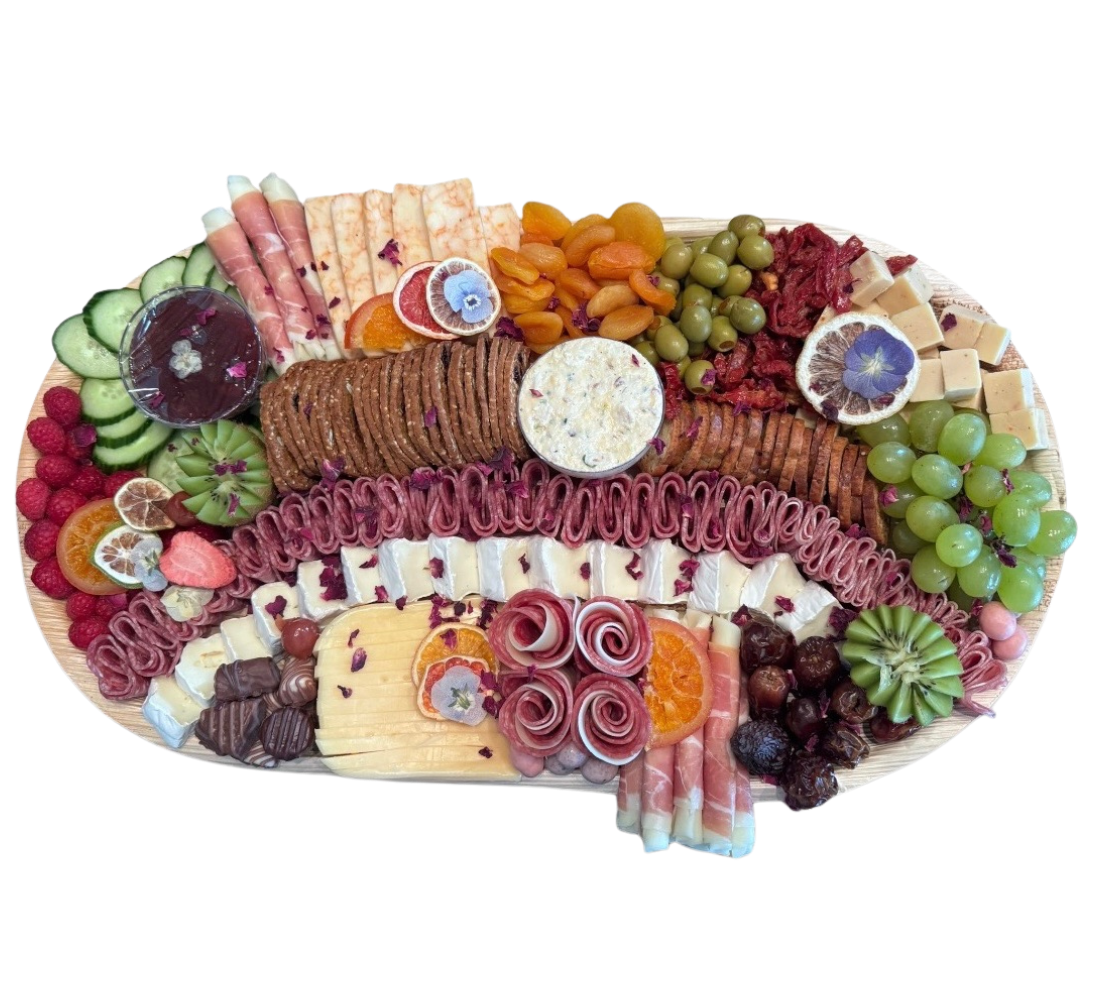 An amazing charcuterie board with cheese, fruit, crackers, meat, and sweet treats all sprinkled with rose petals from Brie & Burrata in San Diego.