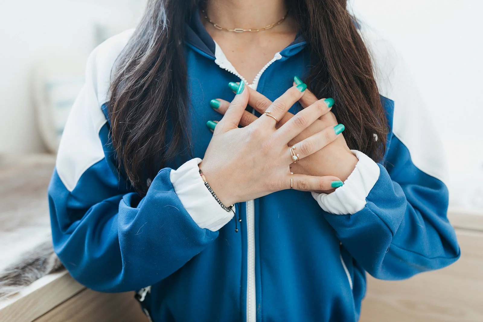 Jena Burton Holistic Health Coach with hands over heart wearing blue and white jacket